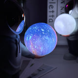 Holding the dreamy starry sky (grey top + navy blue pants) Creative Astronaut Bluetooth Speaker with 3D Starry Sky Lighting, Portable Wireless Moon Lamp Speaker – Perfect Gift for Space Enthusiasts